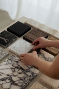 Kaboompics - Hands Styling White Marble and Wood Samples on a Neutral Table