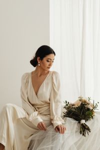 Kaboompics - Bride Seated in an Ivory Wrap Dress Beside a Bouquet