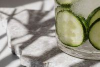 Kaboompics - Close-Up Lime Slices in a Clear Glass on Textured Marble with Hard Sunlit Shadows