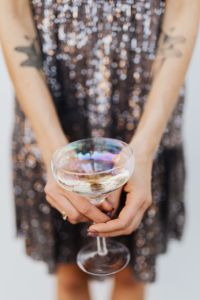 Kaboompics - Champagne Coupe with Tattooed Hands and Silver Sequin Dress