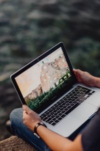 Kaboompics - A man using a Macbook laptop at the seaside
