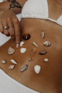 Kaboompics - Woman Pointing to Seashells Arranged on Her Stomach