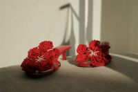 Kaboompics - Red Crochet Flower Sandals on an Upholstered Bench with Soft-Focus Wall Shadows