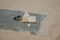 Kaboompics - Open Book and Sunglasses on a Striped Beach Towel