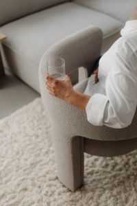 Kaboompics - Top-Down View of Woman Holding a Glass in a Neutral Armchair