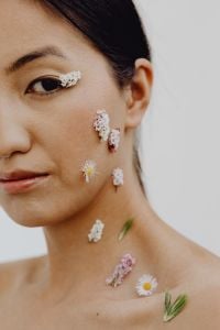 Kaboompics - Asian Woman Portrait with Wildflowers on Cheek, Neck and Shoulder