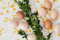 Kaboompics - Yellow Splatter Flat Lay of Easter Eggs and Greenery