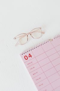 Kaboompics - Vertical Pink Desk Calendar and Glasses for Study, Scheduling and Office Content