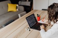 Kaboompics - Woman Using Laptop at Wooden Table in Living Room