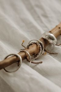 Kaboompics - Silver Rings Styled on a Branch over Textured Linen