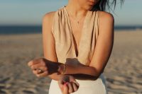 Kaboompics - Woman Adjusting a Bracelet in a Beige Top and White Skirt