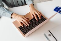 Kaboompics - Top View of Hands Typing on a Pink Laptop with a Calculator