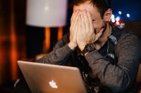 Kaboompics - Man Looking at Laptop beside Christmas Present