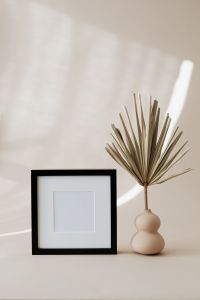 Kaboompics - Minimalist Black Picture Frame and Dried Palm Vase on Beige Wall with Copy Space