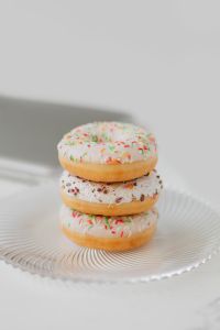 Kaboompics - Stack of Three Iced Donuts with Colorful Sprinkles