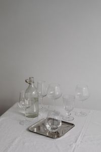 Kaboompics - Bottle and Assorted Wine Glasses Around a Silver Tray on White Tablecloth, Neutral Dining Still Life