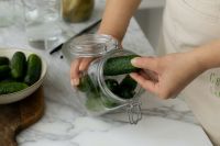Kaboompics - Hands Packing Fresh Cucumbers into an Open Glass Jar