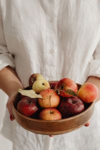 Kaboompics - Woman Holding a Wooden Bowl of Mixed Apples, Seasonal Food and Harvest Lifestyle
