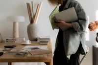 Kaboompics - Interior Designer Carrying Laptop and Design Boards in Creative Workspace