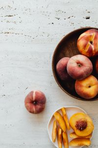 Kaboompics - Wooden Bowl of Peaches with Open Copy Space and Fruit Slices