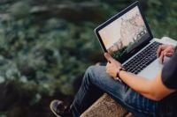 Kaboompics - A man using a Macbook laptop at the seaside
