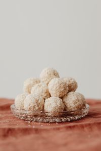 Kaboompics - Coconut Truffles on a Pressed-Glass Plate, Vertical Dessert Still Life with Pale Copy Space