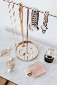 Kaboompics - Silver Wristwatches and Gold Necklaces on a Marble Jewelry Stand beside Perfume