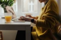 Kaboompics - Side View of Woman Working at Laptop with Orange Juice in a Bright Home Office