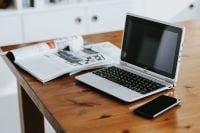 Kaboompics - Laptop, Smartphone and Open Magazine on a Wooden Work Table