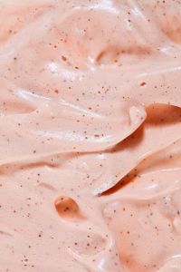 Kaboompics - Vertical Peach Skincare Cream Swirls with Rounded Exfoliating Beads and Fine Speckles