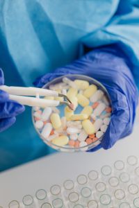 Kaboompics - Close-Up of Tweezers Sorting Tablets in a Petri Dish