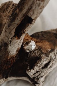 Kaboompics - Polished Silver Statement Ring on Driftwood and Soft Linen