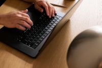 Kaboompics - Man Typing on a Laptop at a Warm Desk