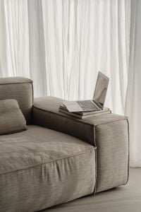 Kaboompics - Open Laptop on Sofa Arm with Stacked Books, Bright Neutral Home Office Background