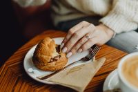 Kaboompics - Fork and Pastry on a Cafe Table beside a Cup of Latte