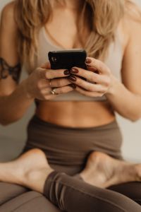 Kaboompics - Close-Up of Woman Holding a Smartphone While Sitting Cross-Legged