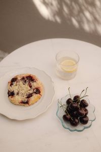 Kaboompics - Outdoor Table with Cherry Pastry, Cherries and Lemon Water