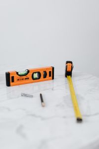 Kaboompics - Spirit Level, Tape Measure, Pencil and Wall Anchors on a Marble Surface, Renovation Tools