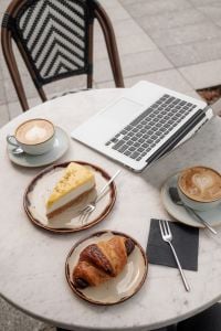 Kaboompics - Coffee Shop Table with Laptop, Cappuccino, Cake and Croissant