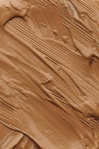 Kaboompics - Warm Tan Foundation Brush Strokes with Raised Cream Texture, Makeup Swatch Background for Beauty Design