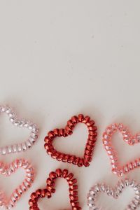 Kaboompics - Red and Pink Beaded Hearts Along the Lower Edge of Beige Background with Copy Space