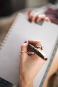 Kaboompics - Writing in a notebook lying in bed, with coffee, candles, and gingerbreads