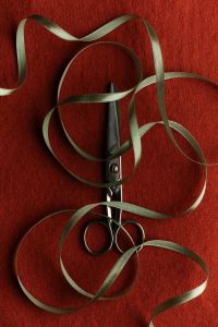 Kaboompics - Green Ribbon and Scissors on Burgundy Fabric