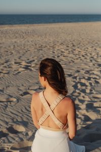 Kaboompics - Woman Sitting on the Sand in a White Skirt: Beach Lifestyle Portrait