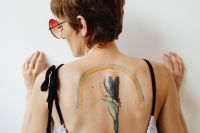 Kaboompics - LGBTQ+ Pride Rainbow Body Paint Framing a Botanical Back Tattoo, Portrait Detail