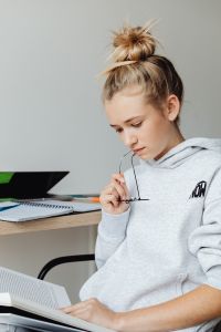 Kaboompics - Girl Reading Textbook While Studying at Desk