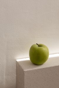 Kaboompics - Green Apple on a Textured Stone Block with Neutral Wall Copy Space, Vertical Food Photo