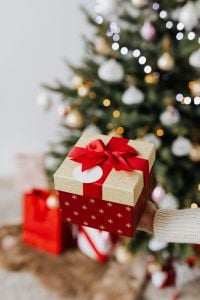 Kaboompics - Red and Gold Christmas Gift with Tree Bokeh and Copy Space