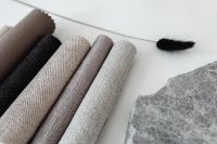 Kaboompics - Rolled Textile Samples with Stone and Black Feather