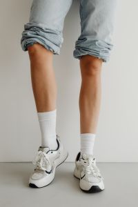 Kaboompics - Rolled-Up Light Blue Jeans and White Sneakers, Minimal Studio Fashion Detail